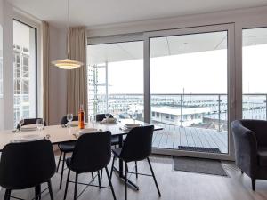 a dining room with a table and chairs and a large window at Apartment Wendtorf VII in Wendtorf