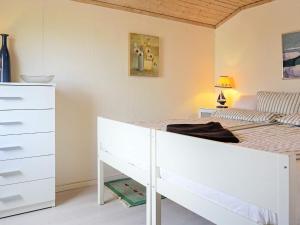 sypialnia z białym łóżkiem i komodą w obiekcie Holiday home STORAHÖGA II w mieście Stora Höga