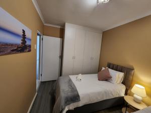 a small bedroom with a bed with white cabinets at Asher's Place in East London