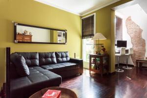 sala de estar con sofá de cuero y espejo en Casa di Gino, en Bolonia