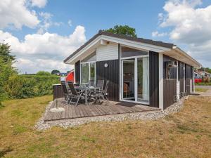 una piccola cabina con tavolo e sedie su una terrazza di Two-Bedroom Holiday home in Grömitz 20 a Grömitz