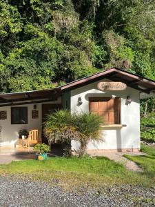 una pequeña casa blanca con una ventana en un patio en Bambito´s Café & Hostel, en Cerro Punta