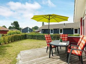 un patio con mesa, sillas y sombrilla en 4 person holiday home in GROEMITZ, en Grömitz