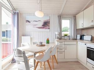 uma cozinha e sala de jantar com mesa e cadeiras em 4 person holiday home in GROEMITZ em Grömitz
