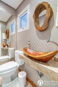 ein Badezimmer mit einem hölzernen Waschbecken und einem WC in der Unterkunft Sua Casa em Canela in Canela + 50 Fotos