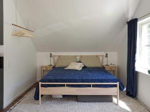 - une chambre avec un lit doté d'une couette bleue et d'une fenêtre dans l'établissement Holiday home RIMBO II, à Rimbo