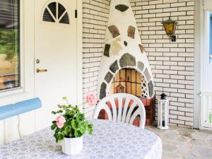 a table and chair on a patio with a pizza oven at 6 person holiday home in TROLLH TTAN in Trollhättan