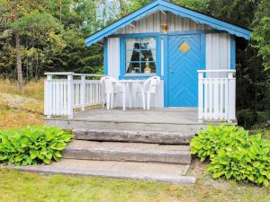 a blue and white shed with a table and chairs at 6 person holiday home in TROLLH TTAN in Trollhättan