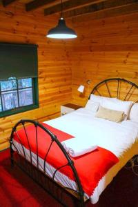 una camera da letto con un grande letto in una camera in legno di Holly Lodge a Medlow Bath