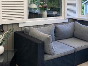 a couch sitting under a window on a porch at 6 person holiday home in L derup in Löderup