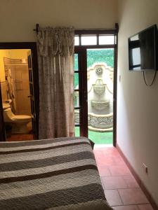 a bedroom with a bed and a door to a bathroom at La casita de Angie in Antigua Guatemala