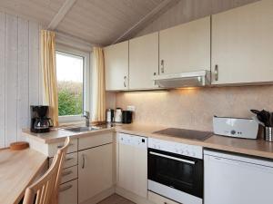cocina con armarios blancos, fregadero y ventana en Two-Bedroom Holiday home in Grömitz 7, en Grömitz