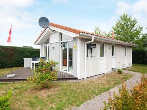 a white tiny house with a deck at Two-Bedroom Holiday home in Grömitz 7 in Grömitz
