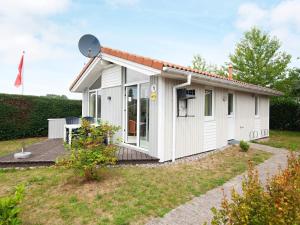 ein weißes, kleines Haus mit einer Terrasse in der Unterkunft Two-Bedroom Holiday home in Grömitz 7 in Grömitz