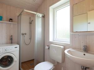 a bathroom with a toilet and a sink and a window at Two-Bedroom Holiday home in Grömitz 7 in Grömitz