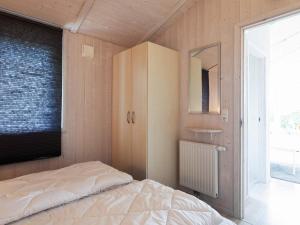 グレーミッツにあるTwo-Bedroom Holiday home in Grömitz 7のベッドルーム1室(ベッド1台、キャビネット、鏡付)