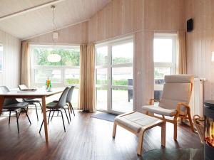 una sala da pranzo con tavolo, sedie e finestre di Two-Bedroom Holiday home in Grömitz 3 a Grömitz