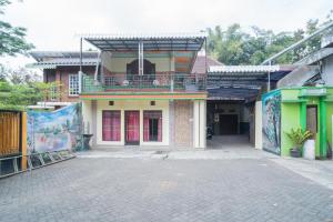 un bâtiment avec un balcon au-dessus dans l'établissement RedDoorz Syariah near Batu Night Spectacular 3, à Batu