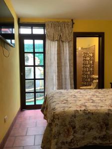 a bedroom with a bed and a large window at La casita de Angie in Antigua Guatemala