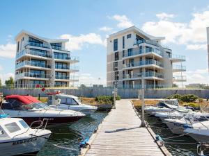 eine Gruppe von Booten, die in einem Yachthafen mit Gebäuden angedockt sind in der Unterkunft Apartment Wendtorf IX in Wendtorf