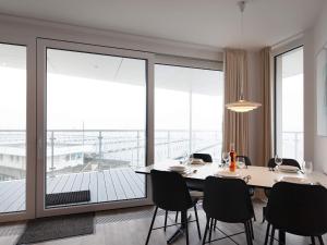 Apartment Wendtorf IX في Wendtorf: غرفة طعام مع طاولة وكراسي وشرفة