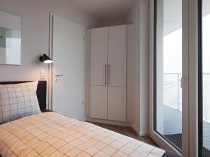 Apartment Wendtorf IX في Wendtorf: غرفة نوم بسرير وباب زجاجي منزلق