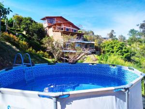 El Peñol的住宿－Donde Andres Campestre - Guatape，房子前面的小型游泳池