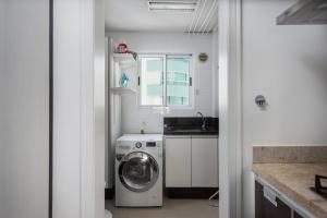 a kitchen with a washing machine and a sink at Apartamento Vista Mar in Balneário Camboriú