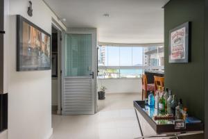a room with a glass door and a table with bottles at Apartamento Vista Mar in Balneário Camboriú