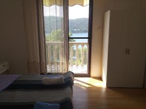 una camera da letto con una grande finestra con vista di Apartments MILA a Ubli