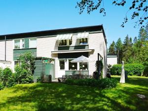 uma casa branca com um relvado à frente em 6 person holiday home in EKER em Ekerö
