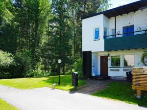 Uma casa branca com um banco à frente. em 6 person holiday home in EKER em Ekerö