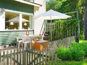 易克略的住宿－6 person holiday home in EKER，一个带桌子和遮阳伞的庭院