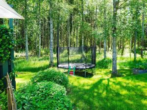 a swing in the middle of a yard with trees at 6 person holiday home in EKER in Ekerö