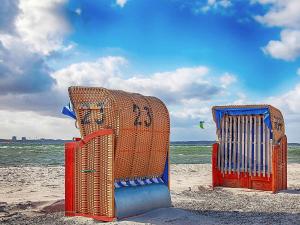 two beach chairs sitting on the sand at the beach at Apartment Wendtorf XI in Wendtorf