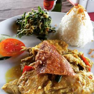 a plate of food with rice and meat and vegetables at Uma Agung Villa in Sidemen