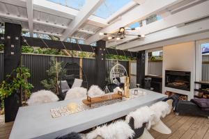 a living room with a white table and chairs at Waterfront Sunsets Studio in Ngunguru