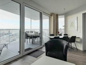 uma sala de estar com uma mesa e cadeiras e uma varanda em Apartment Wendtorf XIII em Wendtorf