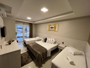 um quarto de hotel com duas camas e uma televisão em Hotel Balneário do Parque em Penha