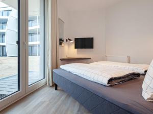 a bedroom with a bed and a large window at Apartment Wendtorf in Wendtorf