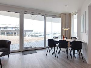 a dining room with a table and chairs and a large window at Apartment Wendtorf in Wendtorf