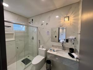 uma casa de banho com um chuveiro, um WC e um lavatório. em Hotel Balneário do Parque em Penha