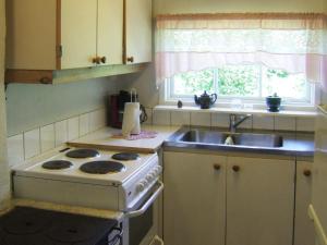 a kitchen with a stove and a sink and a window at One-Bedroom Holiday home in Lerdala 1 in Lerdala
