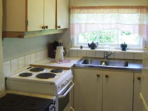 a kitchen with a stove and a sink and a window at 4 person holiday home in LERDALA-By Traum in Lerdala