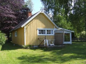 un pequeño edificio amarillo con porche en un patio en One-Bedroom Holiday home in Lerdala 1, en Lerdala
