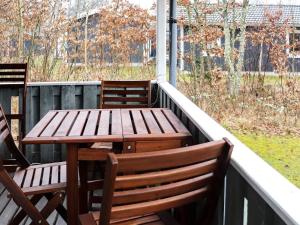 uma mesa de madeira e cadeiras num alpendre em 4 person holiday home in Heberg em Heberg