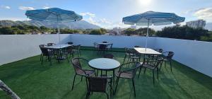 - un ensemble de tables et de chaises avec parasols sur le balcon dans l'établissement Hermoso Apartamento Entero - Parqueadero - Ibague - Roble, à Ibagué
