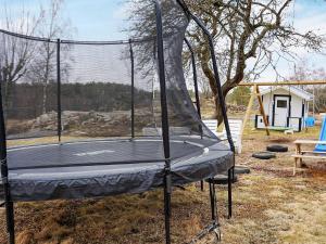 un trampolín en un patio con parque infantil en 5 person holiday home in LINDOME SVERIGE 