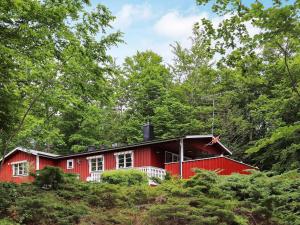 HästvedaにあるHoliday home HÄSTVEDAの木の中の赤い家