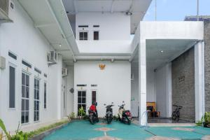 two motorcycles parked inside of a white building at RedDoorz Syariah near Universitas Slamet Riyadi Solo in Karanganyar